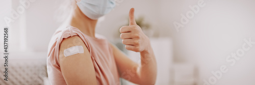 Woman showing thumb up after inoculation against Covid 19. Fototapete