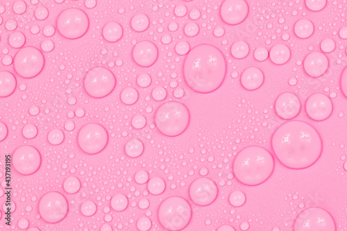 Water drops on pink background texture. Backdrop glass covered with drops of water. scarlet bubbles in water.