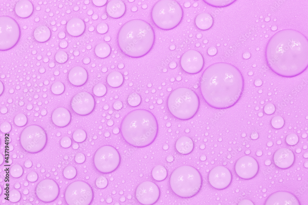 Water drops on purple background texture. Backdrop glass covered with drops of water.  violet bubbles in water