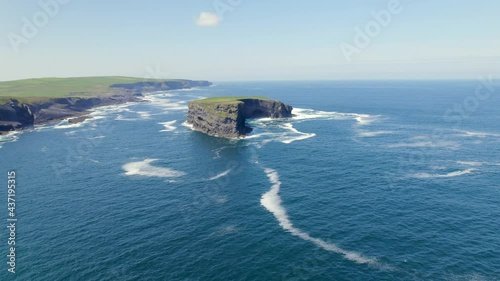 Aerial Spin around Illaunonearaun Natural Heritage Area islet with Kilkee Cliffs in the background. photo