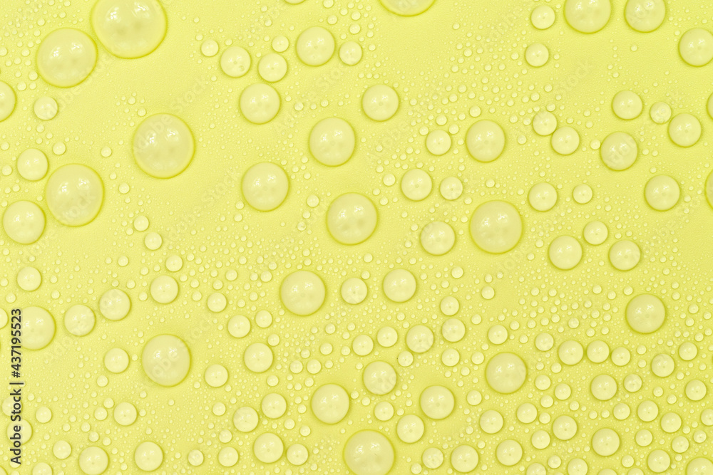 Water drops on yellow background texture. Backdrop glass covered with drops of water. yellow bubbles in water. beer texture