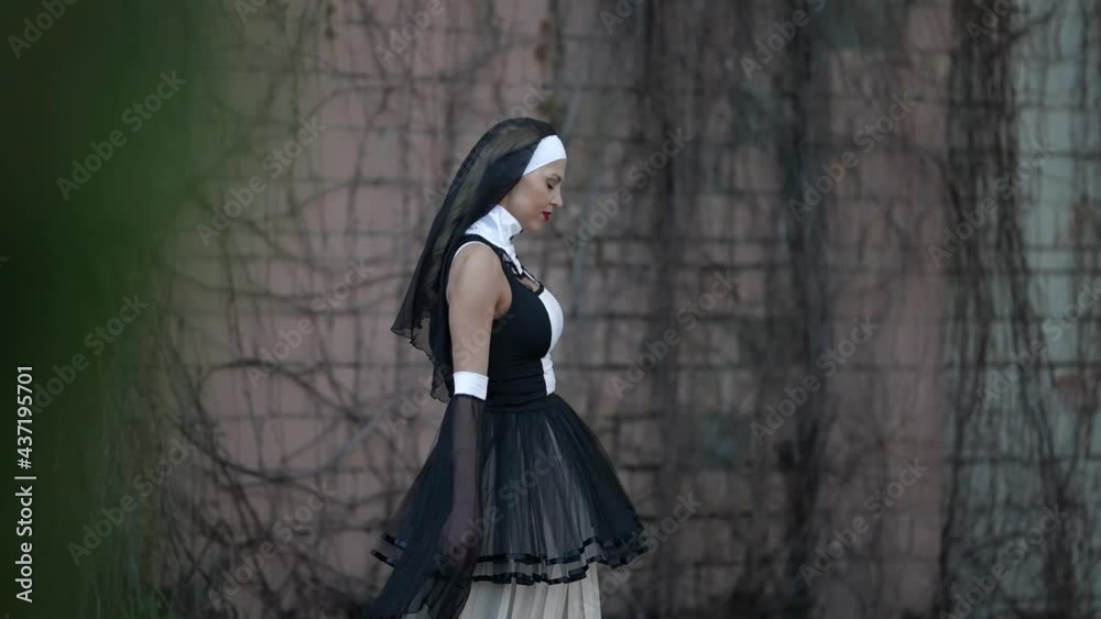 sinful nun is walking alone along wall of old monastery, lost ghost, horror movie Stock Video | Adobe Stock