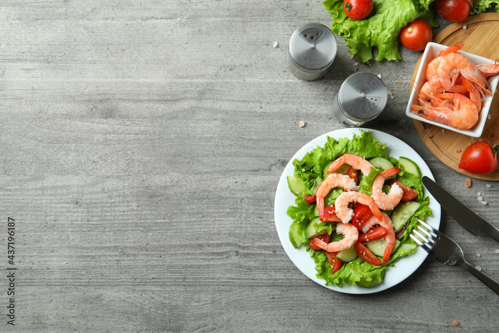 Concept of tasty eating with shrimp salad on gray wooden table