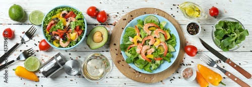 Concept of tasty eating with shrimp salad on white wooden table