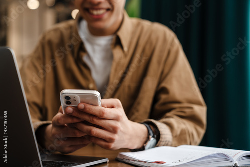 Young hispanic man student sitting at the cafe table indoors