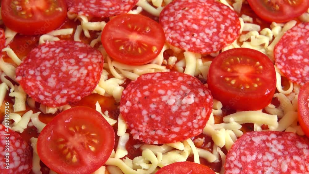 Spinning pizza with mozzarella cheese, tomatoes, tomato sauce and salami. Spinning pizza with mozzarella cheese, tomatoes, tomato sauce and salami.