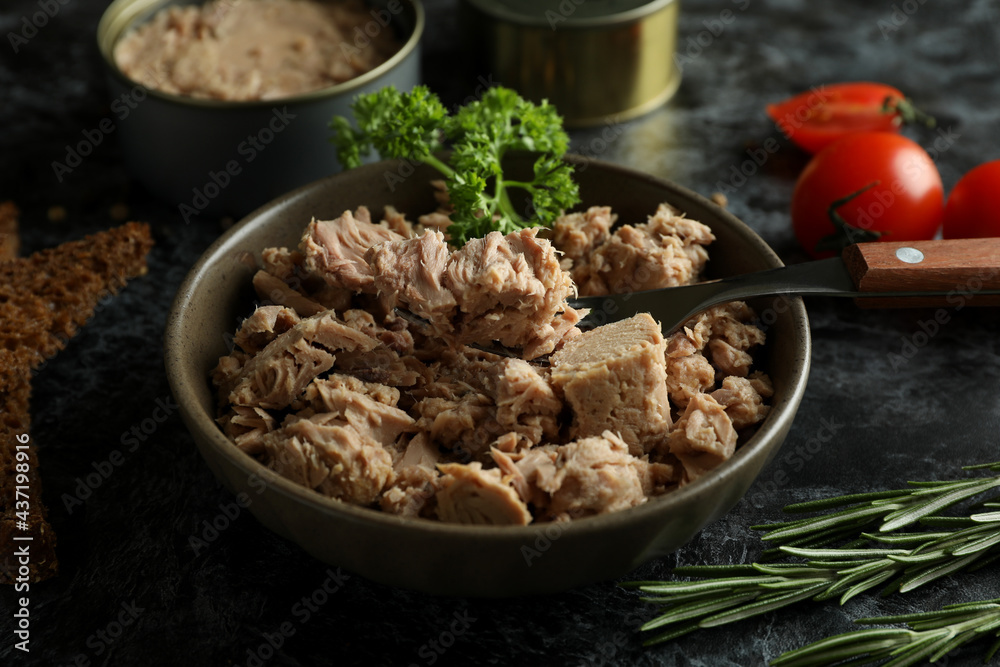 Concept of tasty eating with canned tuna on black smokey background Concept of tasty eating with canned tuna on black smokey background