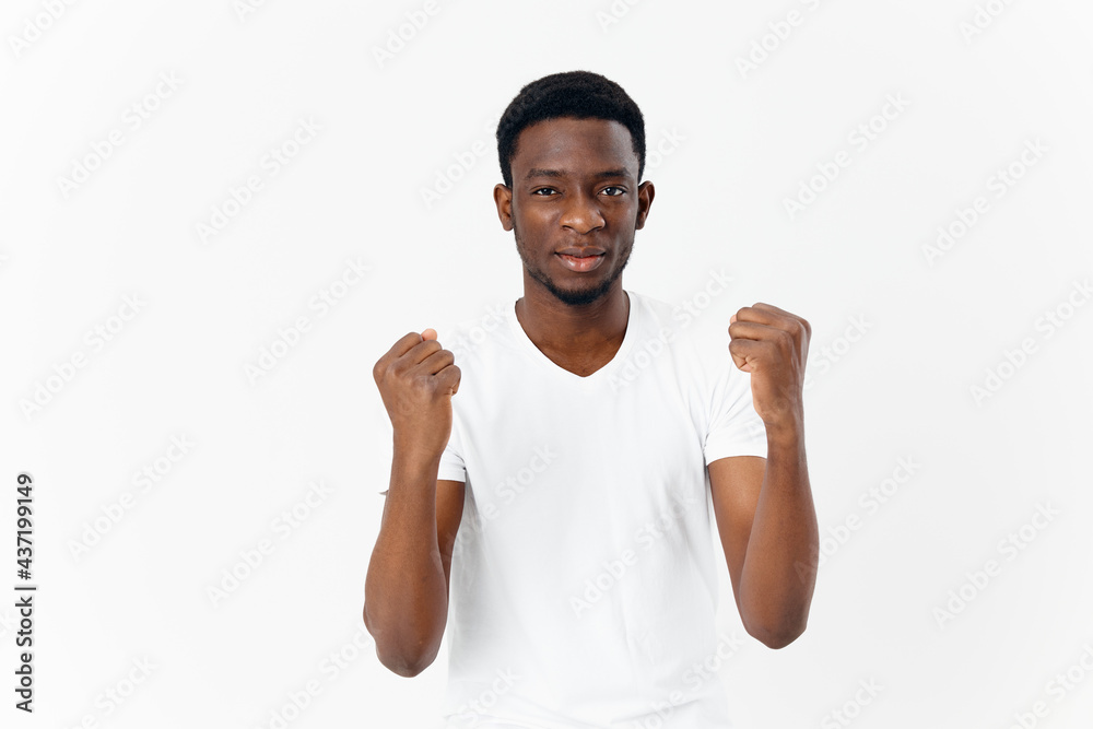 African American in white t-shirt holding hands in front of him cropped view African American in white t-shirt holding hands in front of him cropped view