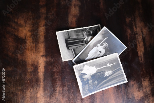 old vintage monochrome photographs of children 1940 - 1950 in sepia color are scattered on wooden table, concept of genealogy, memory of ancestors, family ties, memories of childhood
