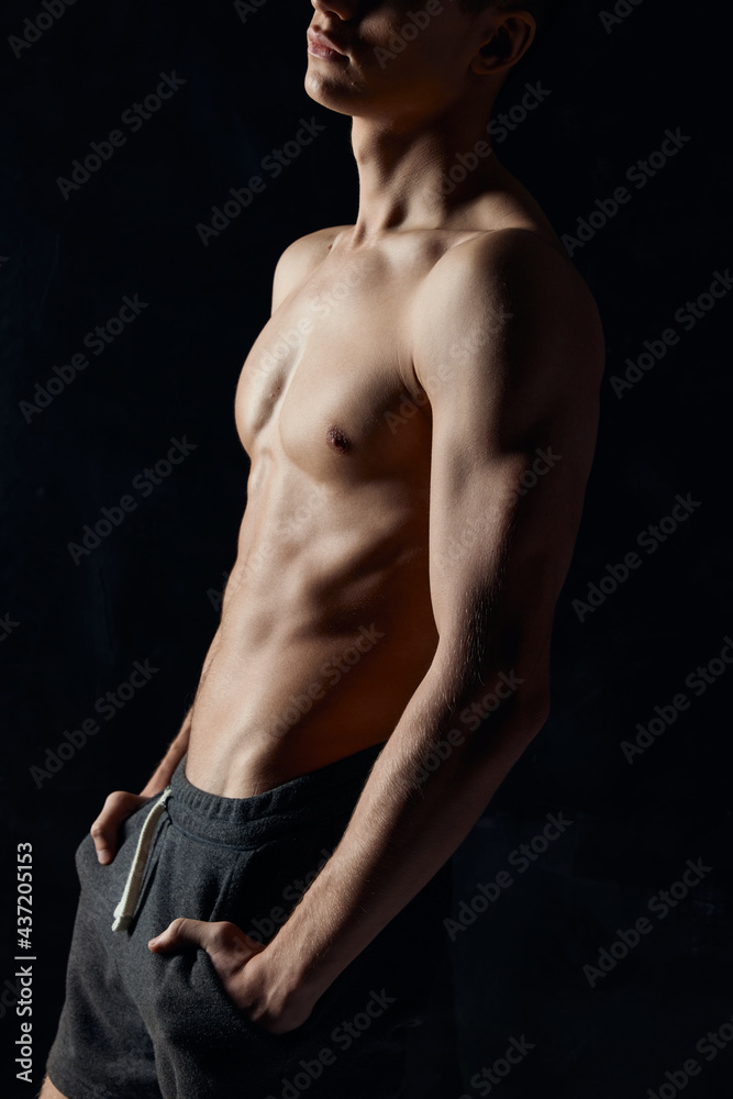 bodybuilder with a naked torso on a black background side view fitness bodybuilder with a naked torso on a black background side view fitness