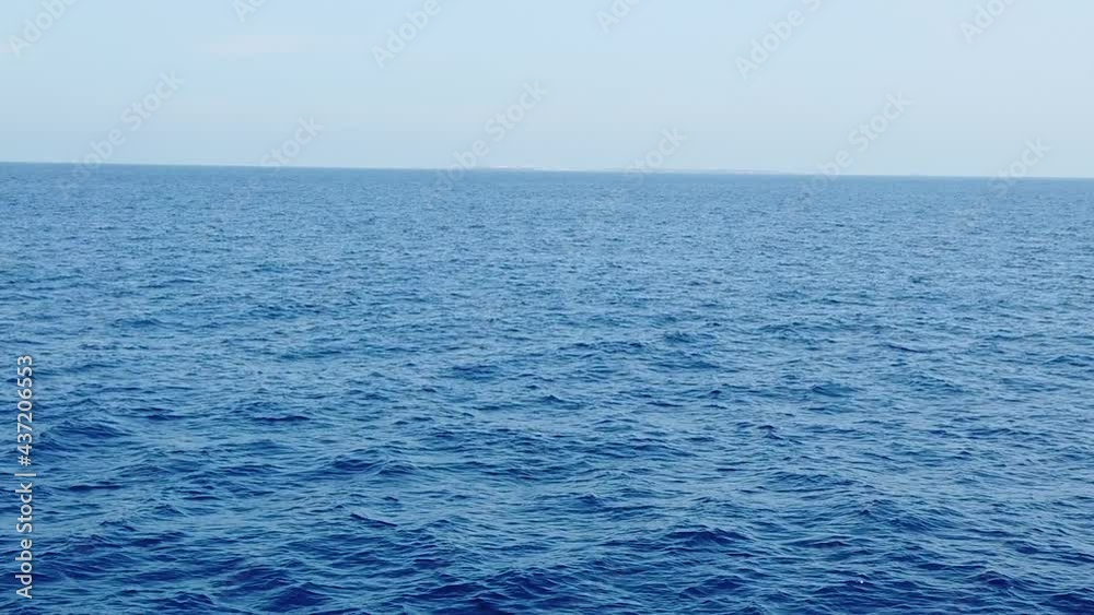 travelling avant en slow motion au dessus de la mer face à une ile à l'horizon