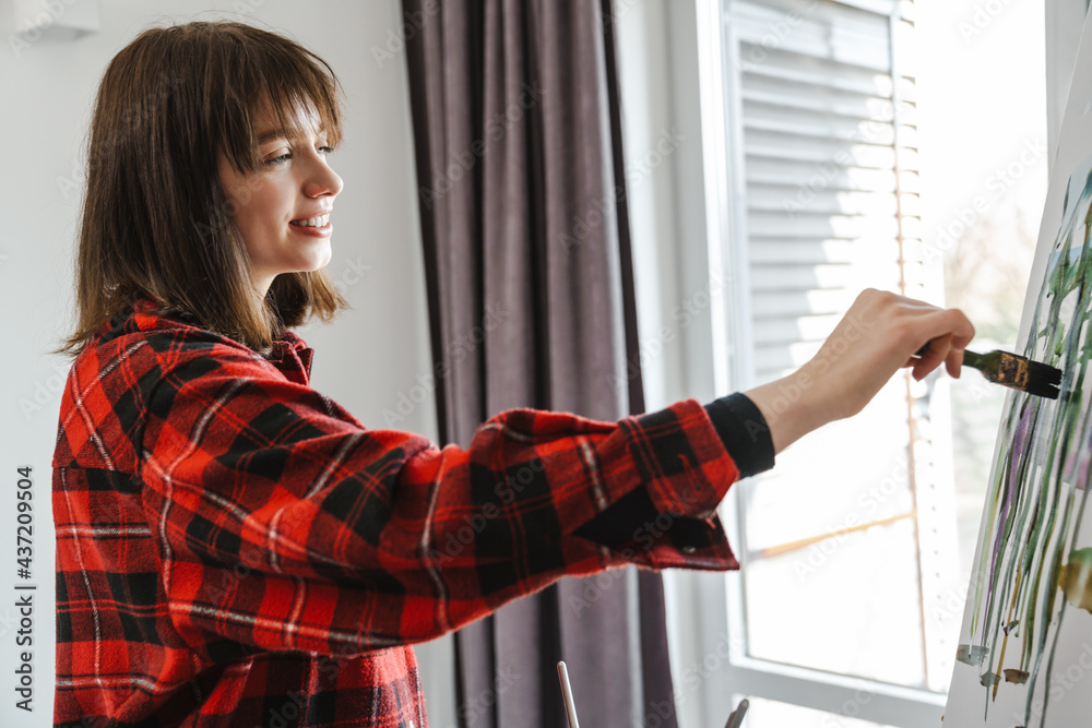 Young white woman in casual wear painting Young white woman in casual wear painting