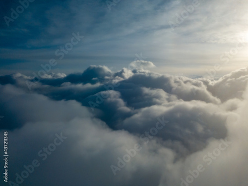 Aerial high flight above the clouds at sunrise.