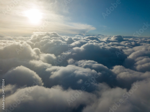 Aerial high flight above the clouds at sunrise. © Sergey