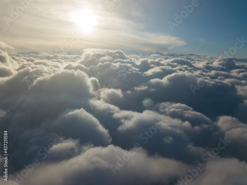 Aerial high flight above the clouds at sunrise.