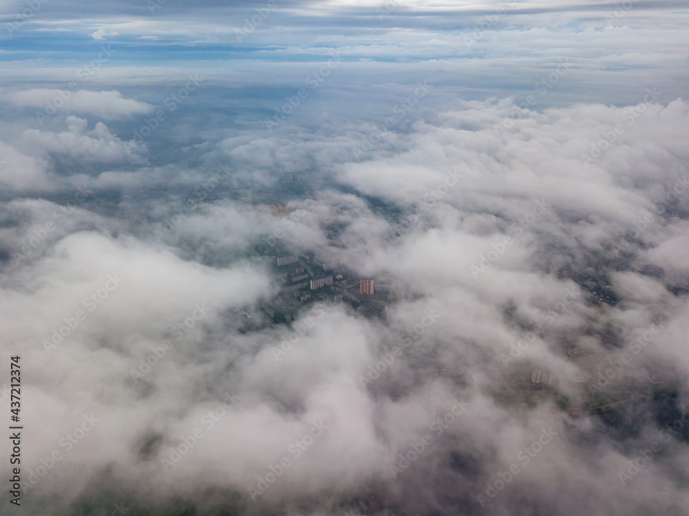 City under the clouds at dawn. Aerial high drone view.