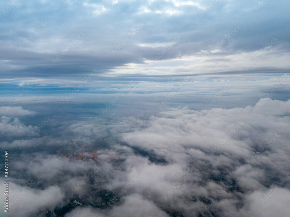 City under the clouds at dawn. Aerial high drone view.