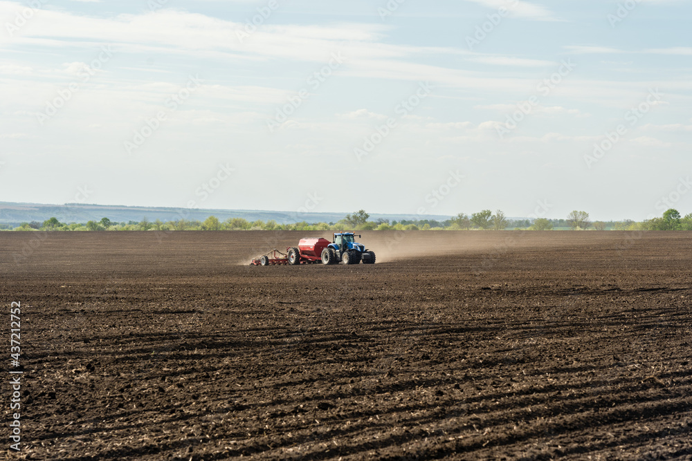 A tractor with cultivator plowing on morning. A tractor with cultivator plowing on morning.