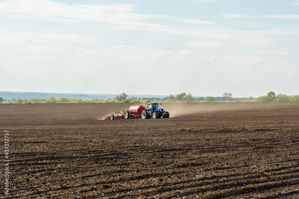 A tractor with cultivator plowing on morning. A tractor with cultivator plowing on morning.