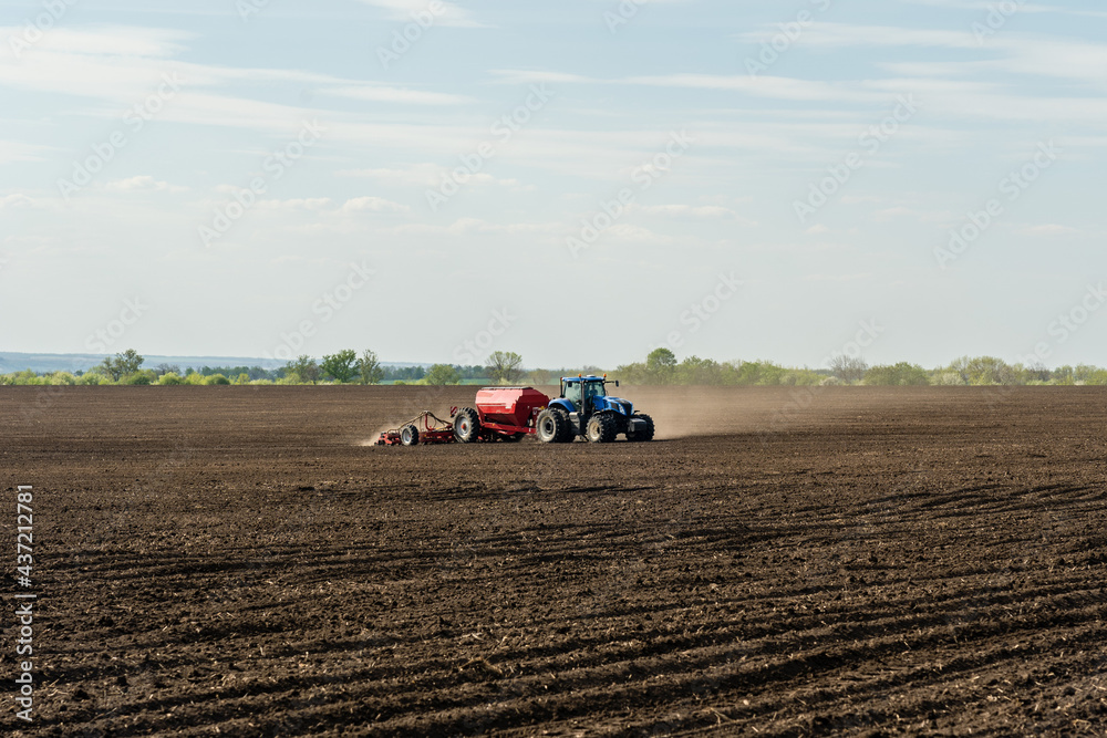 A tractor with cultivator plowing on morning. A tractor with cultivator plowing on morning.