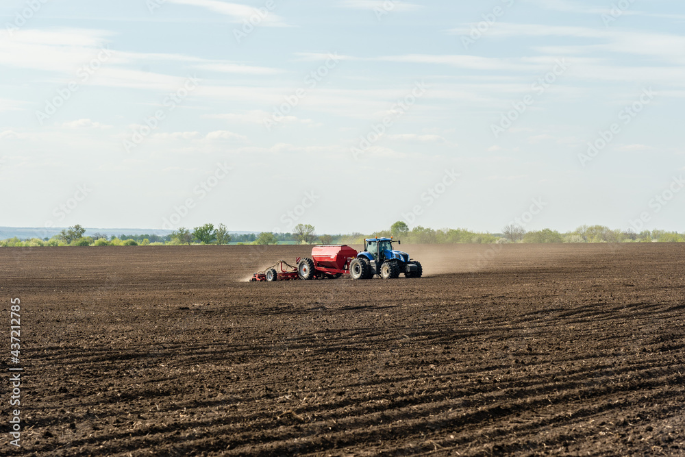 A tractor cultivating field at spring morning. A tractor cultivating field at spring morning.