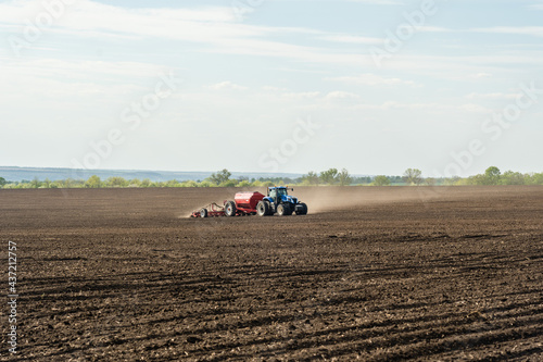 A tractor with cultivator plowing on morning.