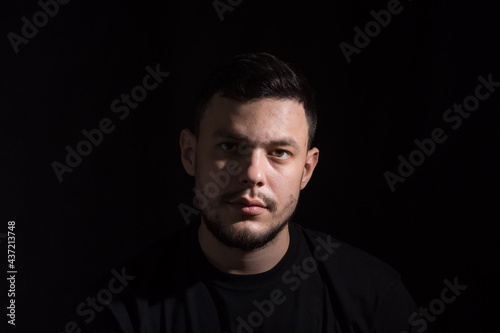 Portrait of a young dark-haired man on a dark background
