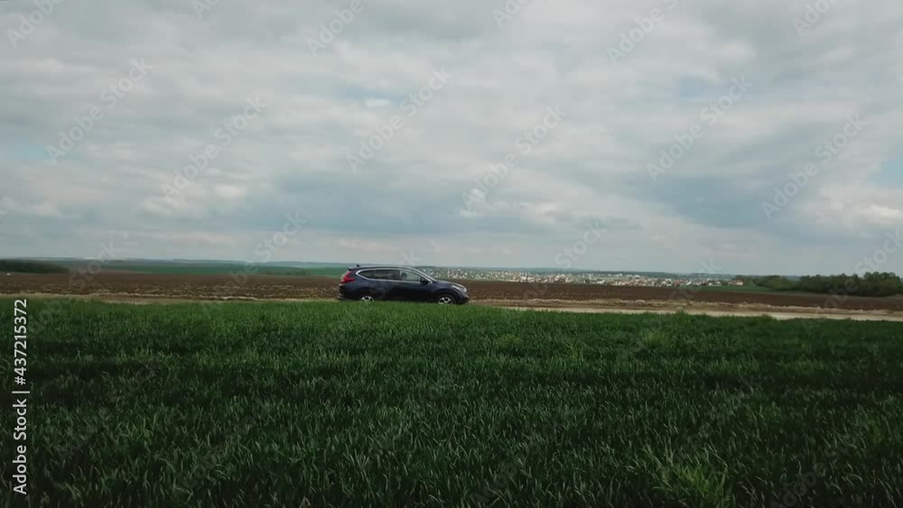 Aerial view. Drone follows to the car. Extreme Automobile driving on the field with green grass. Off-road vehicle. Aerial view. Drone follows to the car. Extreme Automobile driving on the field with green grass. Off-road vehicle.