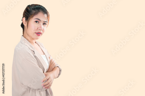 An Asian woman stands with her arms crossed and looks at the camera.