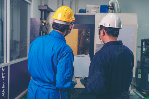 Male industrial engineer or technician worker using control machine operating control CNC machinery at factory Industrial.