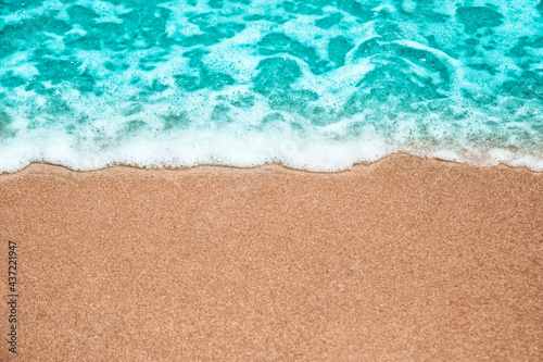 Abstract summer background, Soft wave-covered sand beach with blue water.