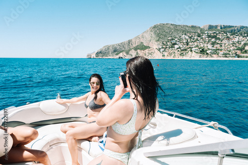 Friends taking pictures  on a boat with a smartphone © noeliauroz