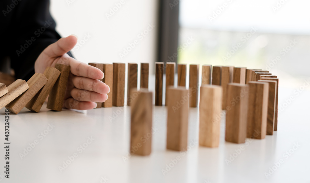 plan and strategy in business protect with balance wooden stack with hand control risk shape.