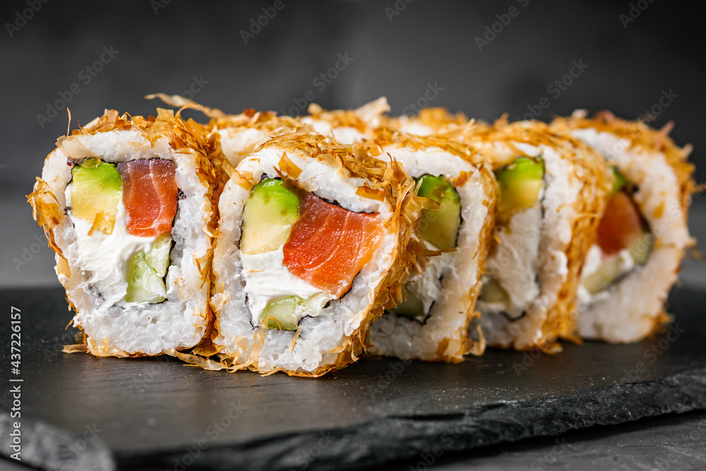 appetizing philadelphia sushi roll with tuna salmon avocado chips and cucumber on a black stone plate appetizing philadelphia sushi roll with tuna salmon avocado chips and cucumber on a black stone plate
