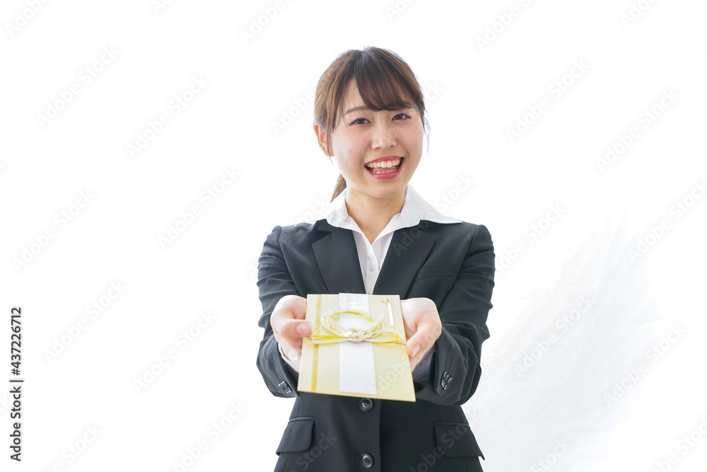祝儀袋を渡すスーツ姿の女性