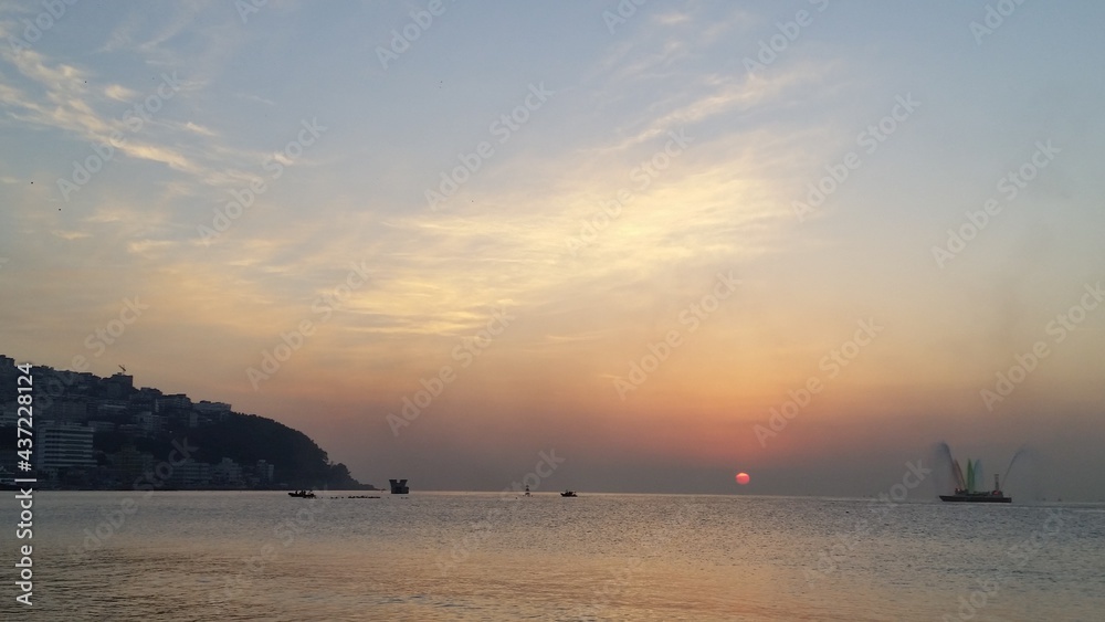 Fototapeta premium 바닷가 저 멀리에서 떠오르는 일출