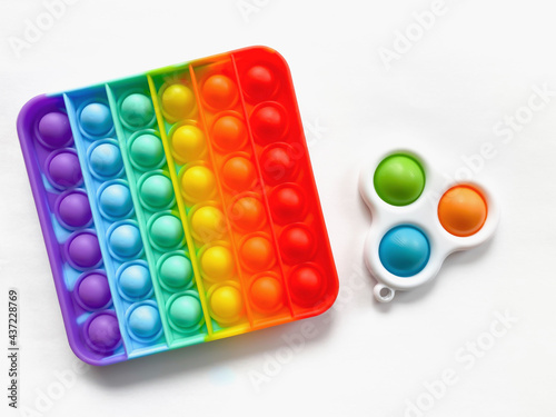 Pop it and Simple Dimple - Antistress toy isolated on a white background.  A popular soothing toy for children and adults.  Soft silicone bursting bubbles in rainbow colors.  Flat lay.
