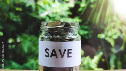 Coins in glass jar for money saving financial concept.