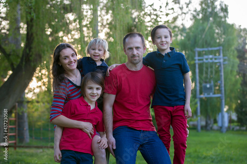 Spring portrait of happy family in nature on sunset © Tomsickova