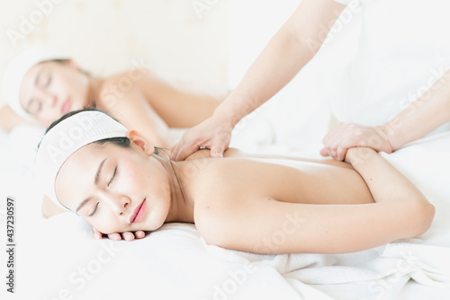 Happy female lying on stomach on massage table getting back beauty treatment. Happy young woman receiving massage at spa.