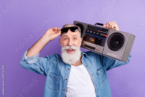 Photo of aged man happy positive smile hold retro boombox audio music isolated over violet color background