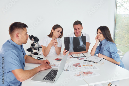 X-ray of legs. Group of young doctors is working together in the modern office