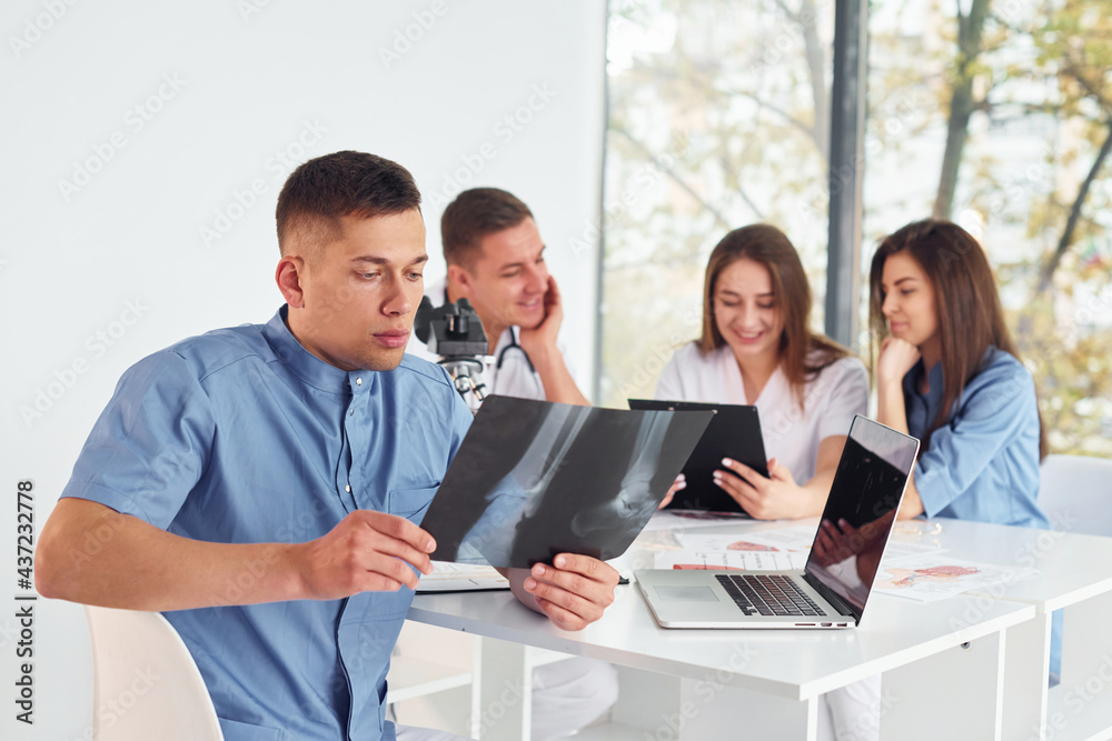 X-ray of legs. Group of young doctors is working together in the modern office