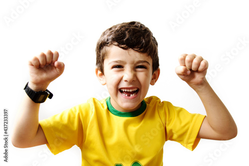 Brazilian boy, soccer player and fan, celebrates making a gesture with his hands over white background.  Sports fan cherring.