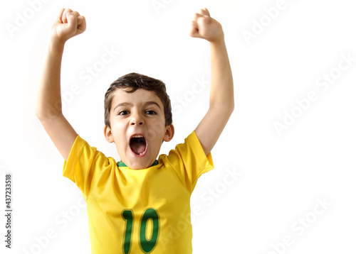 Brazilian boy, soccer player and fan, celebrates making a gesture with his hands over white background.  Sports fan cherring.