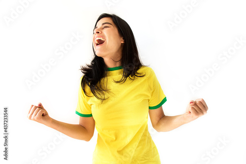 Sport fan Cherring. Beautiful brunette girl in yellow uniform. Woman celebrates sports and game over white background.