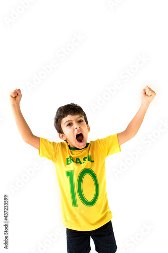Brazilian boy, soccer player and fan, celebrates making a gesture with his hands over white background.  Sports fan cherring.