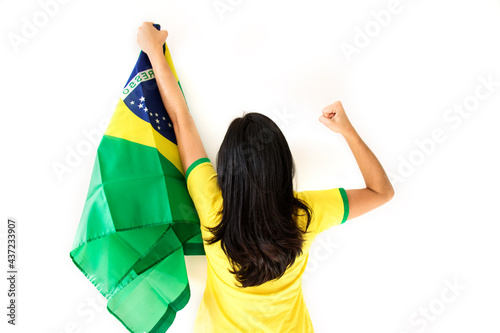 Sport fan Cherring. Beautiful brunette girl in yellow uniform. Woman celebrates sports and game over white background.