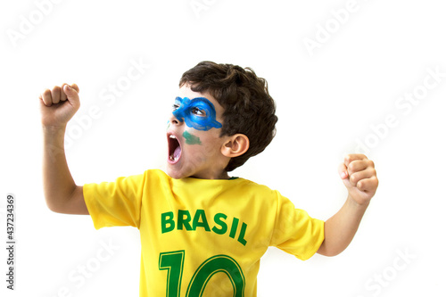 Brazilian boy, soccer player and fan, celebrates making a gesture with his hands over white background.  Sports fan cherring.