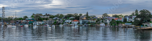 View of residential properties on Sydney harbour foreshore and sail boats yachts moored in the Bay NSW Australia 